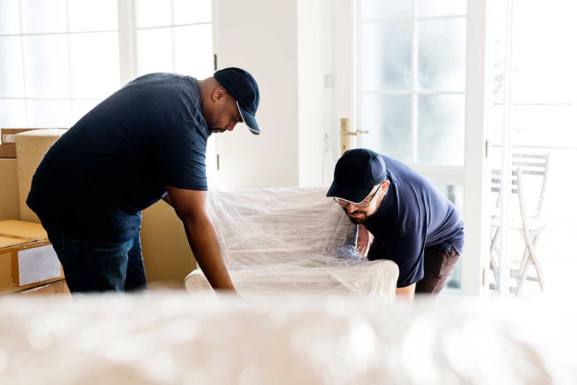 Presto Movers crew wrapping and protecting a piece of staging furniture