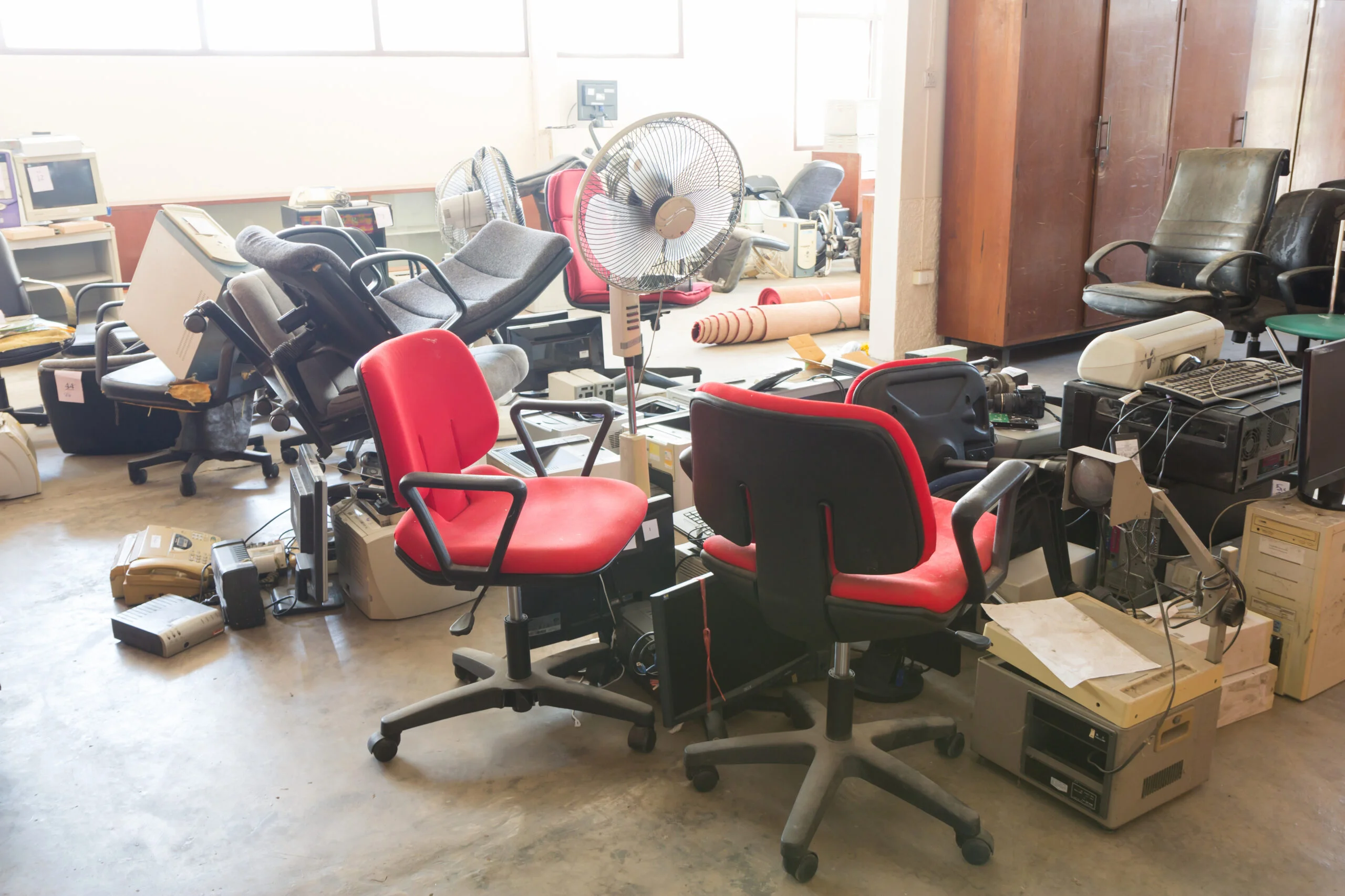 Retired classroom desks and surplus equipment staged for liquidation or recycling